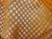 Close up of the commercial grade polyester material of our orange mesh laundry bag.