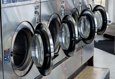 How are mesh net laundry bags used in institutional washing machines?